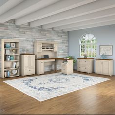 a room with blue walls and wooden floors, white furniture and a rug on the floor