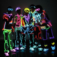 three people standing next to each other with neon lights on their faces and hands in front of them