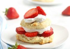 strawberry shortcakes stacked on top of each other with whipped cream and strawberries