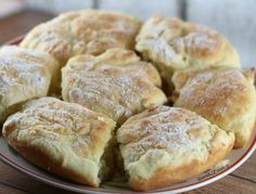 a plate full of biscuits sitting on top of a wooden table