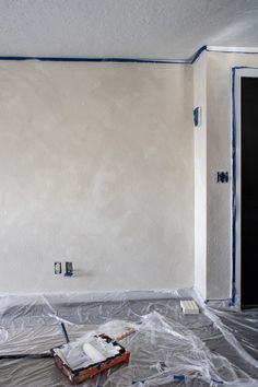 an empty room is being painted white with blue tape