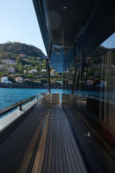 the back deck of a boat with mountains in the background and blue water on both sides