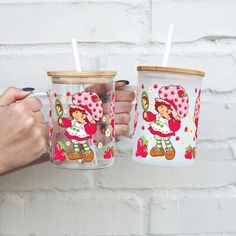 two people holding cups with straws in them