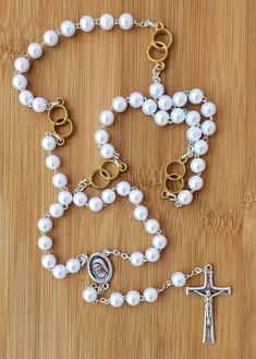 "Personalized rosary with white pearls beads for wedding. Wedding rosary with a name for newlyweds. If you want to brighten up someone's wedding day and give them a personal gift, you can order a wedding rosary with a name. This beautiful rosary it's perfect gift for wedding. In every part of Our Father is two rings what symbolizes weddings. Its made with medal Virgin Mary and cross MIR, MIR, MIR ( PEACE, PEACE, PEACE). You can order: 1.only rosary 2.rosary with one name(only bride or only groom Elegant White Pearl Rosary, White Pearl Drop Jewelry For Marriage, Pearl White Rosary For First Communion, White Pearl Rosary As A Gift, White Pearl Rosary As Gift, Spiritual Wedding Jewelry With 8mm Beads, Spiritual 8mm Beads Jewelry For Wedding, Silver Pearl Rosary For First Communion, Wedding Rosary Bracelet With Pearl Charm