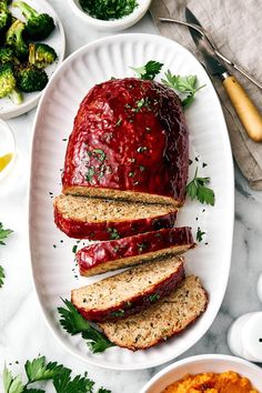 sliced meatloaf on a plate with carrots and broccoli