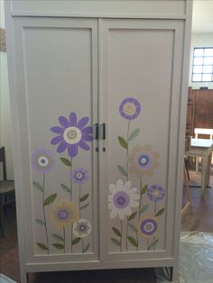 a cabinet with flowers painted on the doors