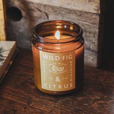 a candle sitting on top of a wooden table next to a book and some books