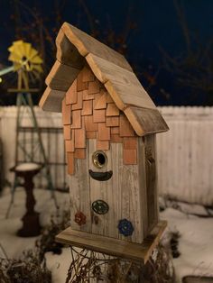 a birdhouse made out of wood with buttons on it