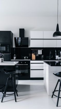 a black and white kitchen with two stools