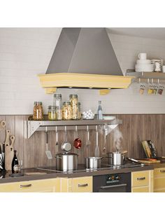 a stove top oven sitting inside of a kitchen next to yellow cabinets and counter tops