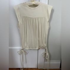 Unworn Isabel Marant White Sleeveless Blouse With Fringe Side Tie Detail. 100% Silk Sleeveless Tops With Drawstring Tie, Elegant Summer Tops With Drawstring Tie, Chic Fitted Top With Drawstring Tie, Fitted Sleeveless Top With Drawstring Tie, Cream Sleeveless Top For Daywear, White Silk Blouse, White Sleeveless Blouse, Tie Colors, White Sleeveless