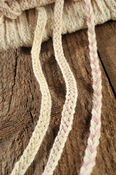 a close up of a white and pink rope on a wooden surface with wood flooring