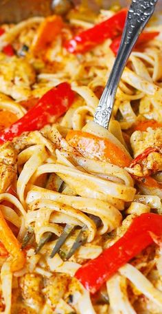 a pan filled with pasta and vegetables being stirred with a fork by a spatula