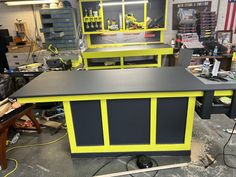 the workbench is painted bright yellow and gray with black accents, along with other tools