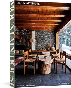 the mountain house book is on display in front of a stone wall and wooden ceiling