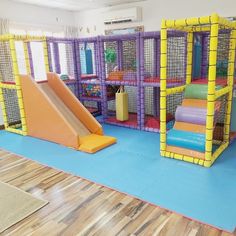 an indoor play area for children with slides and climbing mats on the floor in front of them