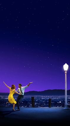 a man and woman dancing in front of the city at night with stars above them