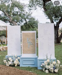 an outdoor ceremony setup with flowers and burlock on the back of two large boards