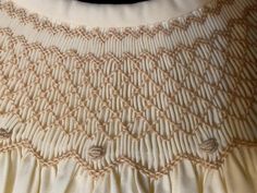 a close up of a white dress on a mannequin neckline with buttons