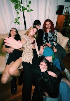 a group of people sitting on top of a wooden floor in front of a white curtain