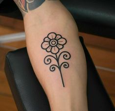 a woman's arm with a flower tattoo on the left side of her leg