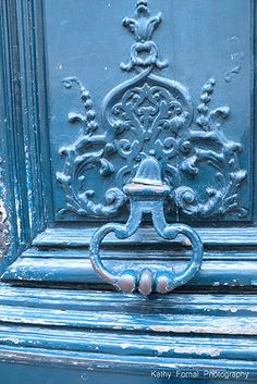 an ornate blue door with a metal handle