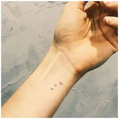 a person's arm with a small tattoo on the left side of their wrist