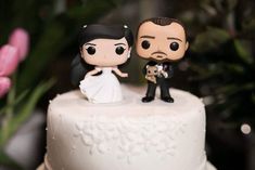 a bride and groom figurine on top of a wedding cake