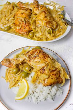 two plates filled with pasta and chicken on top of white rice next to lemon wedges