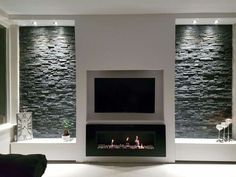 a living room with a fire place and stone wall