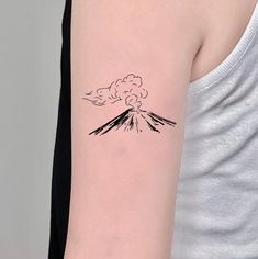 a woman's arm with a black and white ink drawing of a volcano on it