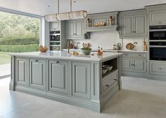 a large kitchen with gray cabinets and marble counter tops