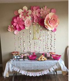 a table topped with lots of pink flowers and cupcakes on top of it