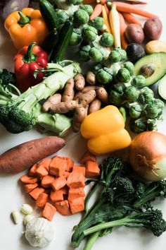 many different types of vegetables on a white surface