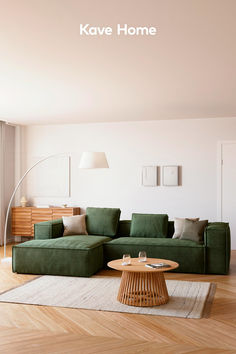 a living room with a green couch and coffee table on the floor in front of a white wall