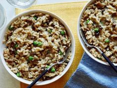 two bowls filled with rice and peas on top of a table