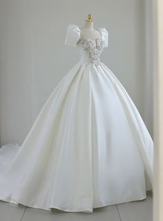 a white wedding dress on display in a room