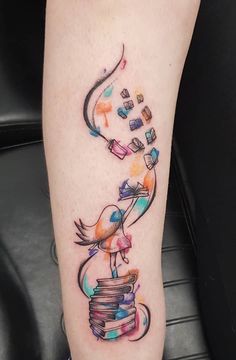 a colorful tattoo on the leg of a woman with books and birds flying out of it