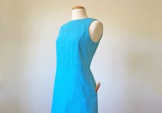 a woman's blue dress on a mannequin headdress with buttons