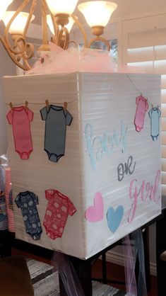 a box with clothes on it that says baby one girl hanging from the top and underneath