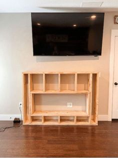 a flat screen tv mounted above a wooden entertainment center