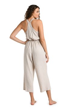 Effortlessly chic, this taupe-colored cover-up complements any beach ensemble, offering a versatile and neutral layer for your seaside adventures. This jumpsuit features a cropped, wide-leg design, with adjustable shoulder straps and a drawstring waist for a customizable fit. The back showcases a cross-strap detail, adding a touch of elegance to the relaxed fit, making it both functional and fashionable for summer days. [split] Details Jumpsuit cover up Cropped length Drawstring waistband Pocket Beige Linen Summer Jumpsuits And Rompers, Beach Jumpsuits And Rompers With Adjustable Straps, Chic Jumpsuits And Rompers With Adjustable Straps For Vacation, Beige Jumpsuits And Rompers With Elastic Waistband For Spring, Chic Beach Jumpsuits And Rompers With Adjustable Straps, Neutral Summer Casual Jumpsuits And Rompers, Linen Jumpsuit For The Beach, Neutral Casual Jumpsuits And Rompers For Summer, Casual Beige Jumpsuits And Rompers For Vacation