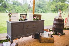 an outdoor wedding reception setup with flowers on the dresser