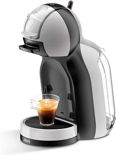 an espresso machine with a cup of coffee next to it on a white background