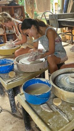 two women are making pottery in a workshop