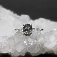 a diamond ring sitting on top of some white rocks in front of a black and white background