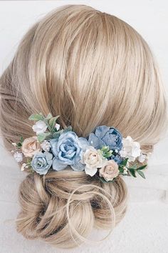 a woman with blonde hair and blue flowers in her hair is wearing a flower crown