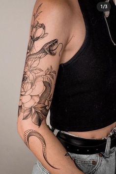 a woman with a snake and flowers tattoo on her arm, holding onto her stomach