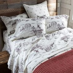 a bed with white and red comforters in a bedroom