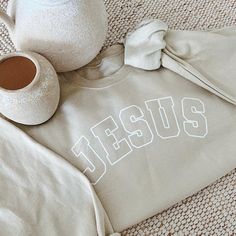 "Jesus" beige sweatshirt. This beautifully designed sweatshirt is a comfortable and stylish way to express your faith and gratitude. * 100% ring-spun cotton * Soft ring spun cotton fabric with 100% cotton threads * True to size unisex fit   Share your faith and stay warm in style with our "Jesus" Christian sweatshirt. Order yours today and make a powerful statement of faith wherever you go.   Care Instructions: - Wash inside out with cold water - Do not bleach - Do not Iron on the logo - Low setting for tumble dry  *ALL SALES ARE FINAL Statement Of Faith, Christian Sweatshirts, Beige Sweatshirt, Merch Ideas, Fall Fit, Christian Sweatshirt, Fit Ideas, Fashion Group, Soft Ring